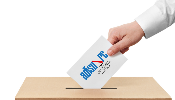 una mano che imbuca la cartella di voto nell'urna