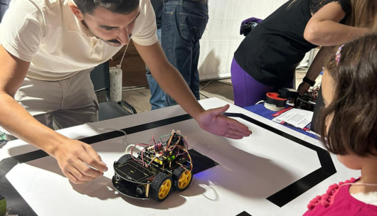 foto di un ricercatori con un'auto elettrica